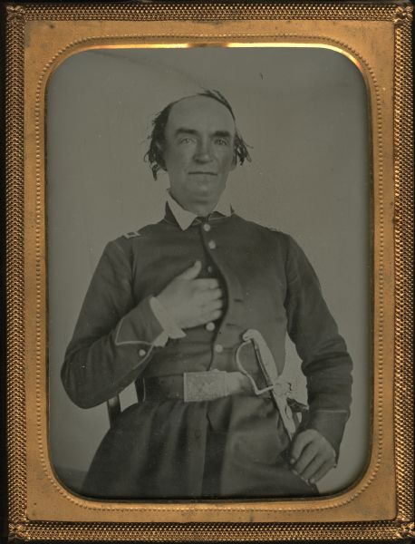 Quarter-plate ambrotype. Three-quarter length portrait of John H. Fonda, settler in the Prairie Du Chien area. He is sitting facing front, with one hand inside his belted coat front, and the other hand resting on a sword at his left hip. There is an eagle on his belt buckle. Back of frame has a paper attached which reads: "Prairie du Chien, an early pioneer of Wisconsin."