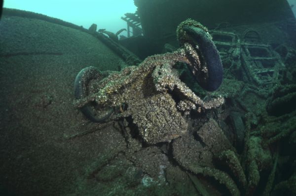 Underwater view of a pile of automobiles and other pieces of cargo that sank with the <i>Lakeland</i>. In the foreground an upside down automobile is resting on top of various pieces of the wreckage.