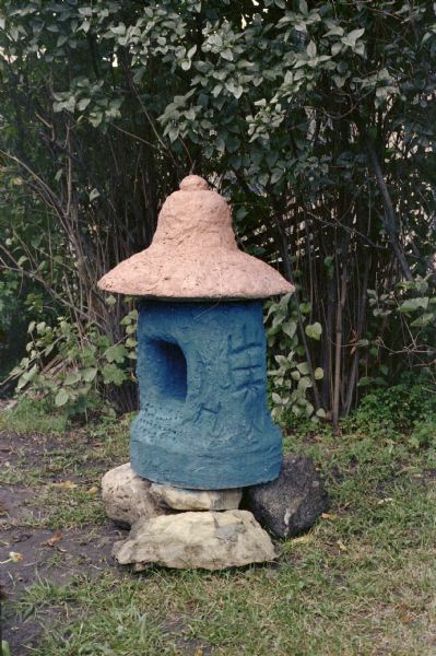 Red and Blue Lantern in Sid's Backyard Red and blue lantern set up on rocks in Sid's backyard.