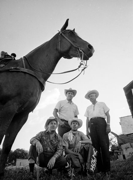 The 12th Annual World Championship Rodeo is held at the Holmes No-Oaks Ranch, Syene Road. Members of the rodeo planning committee are kneeling. They are (L-R) Robert Kilgore, 3810 Johns St., ticket chairman; and Joseph Boberschmidt, 5022 Sherwood Rd., area director, and (standing, L-R)  James Holmes, Syene Rd., general chairman; and Frank Holmes, Syene Rd., producer.