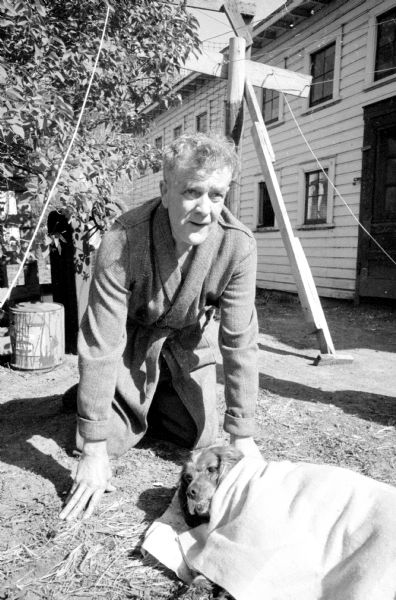 Bjarne Bendixon and Dog Sandy Bjarne Bendixson on his hands and knees, leaning over his dog, Sandy, wrapped in a blanket. They were saved by their housekeeper when fire flashed through the kitchen of their home at 906 East Mifflin Street.