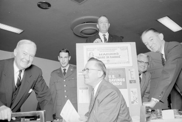 U.S. Savings Bond Campaign Arnold G. Gehner, center, vice president of the Bank of Madison, is general chairman for the "Share-in-America" Madison area U.S. savings bond purchasing campaign, which was held at the Park Hotel. Others who attended a planning meeting are, left to right: Harold Dickens, Milwaukee state director of U.S. savings bonds program; Lt. Harold Frye from Truax Field; I.W. Lackore, executive secretary, Madison Chamber of Commerce; James Callan, Milwaukee, state representative of U.S. Treasury Dept. savings bond division; and Herbert Heasley, Washington, D.C., national representative of the division.