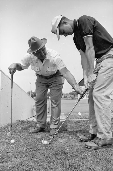 Vitense Golfland City golf champion, Tim Zwettler, right, receiving advice from his first teacher, George Vitense, at the Golfland; a combination miniature golf course, a par-three 18 hole course, and a driving range.
