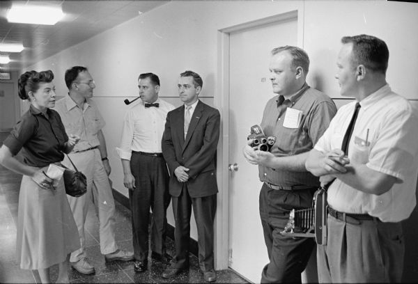 Reporters Outside Firemen's Pension Board Meeting Room Group of reporters, including June Dieckmann, standing outside the Madison Firemen's Pension Board meeting room waiting to hear the outcome of their decision on whether to retain Edward Durkin in his position as First Assistant Fire Chief. The vote was unanimous to keep him in that position despite the police and fire commissions' effort to force him to retire.