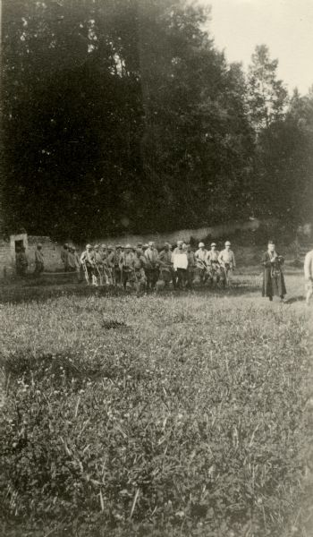 French Soldier Burial View across field towards a group of French soldiers. Caption reads: "The funeral procession of a dead French soldier. Whenever possible, a military burial is given. Notice the priest-captain leading the procession."