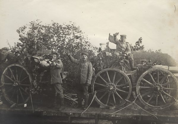 "Hurrah, We're Heading to the Front" German soldiers and artillery caissons loaded on a flat car.