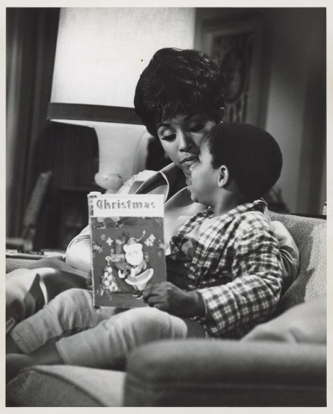 "Julia" publicity photograph Diahann Carroll, the star of the 1968-1971 TV series "Julia" sits next to Marc Copage, who played her son Corey on the show, on a couch. Marc holds a Christmas book.