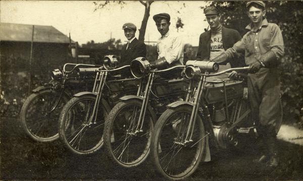 Silas Pifer (second from left), George Standon (third from left) and two other men pose with their Harley-Davidson motorcycles.  Fourth from left is another member of the Standon family, first name unknown.