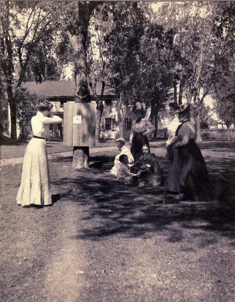 Target shooting on the east lawn of Villa Louis. Nina S. Dousman is on the extreme right of the image.