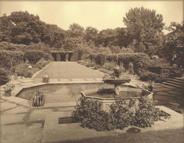 The garage and garden at "Walden", the estate of Cyrus McCormick, Jr., showing a fountain and pond in the foreground.