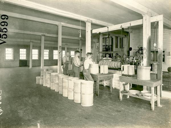 Workers paraffining cheese at the Sheboygan County Farmers' Coop cheese factory.