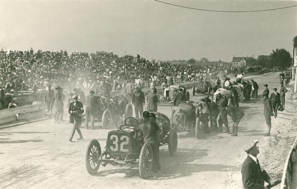 Slightly elevated view of drivers making last minute adjustments to their automobiles at the start of the Milwaukee Grand Prize race (later called the American Grand Prix).