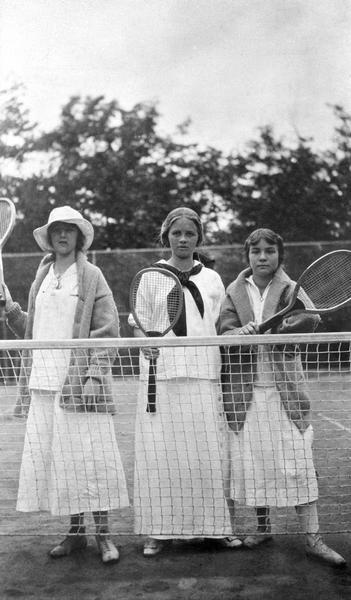 Elizabeth Hull, Elizabeth Baker, and Elizabeth Nisbet standing at the tennis court net at Coole Park Manor.