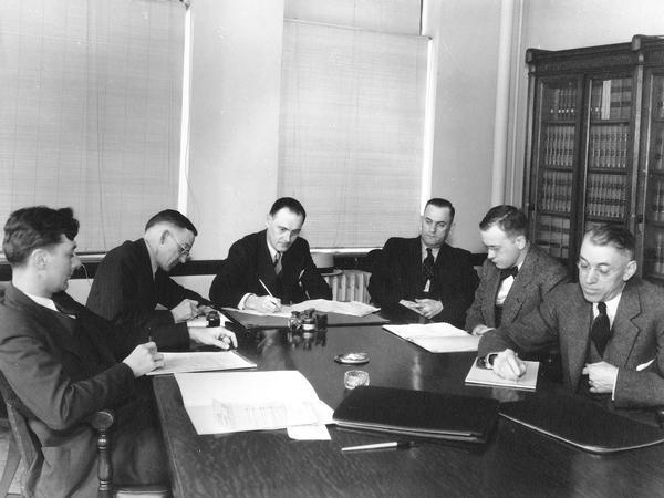 Photograph of Industrial Commission members at a compensation hearing.