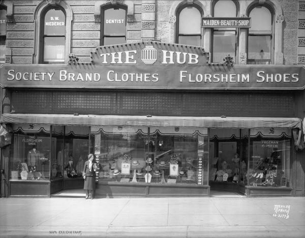 Exterior of the Hub clothing store, located at 22-24 West Mifflin Street. A sign reads: "Society Brand Clothes and Florsheim Shoes." Second floor windows have signs that read: "Dr. R.W. Niederer, Dentist" and "Maiden Beauty Shop."