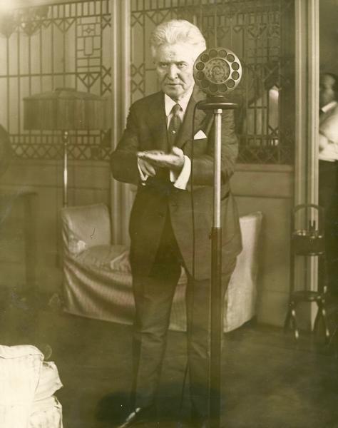 Independent presidential candidate Robert M. La Follette, Sr., standing behind a radio microphone delivering a Labor Day address.