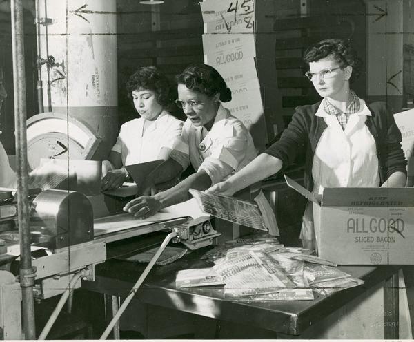 Three women packing "All Good" brand bacon.