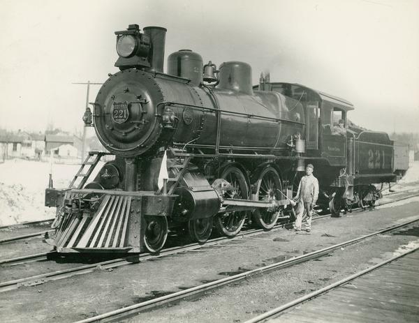 Wisconsin Central Railway locomotive no. 221, the first "big engine" on the Wisconsin Central.  Built by the Brooks Locomotive Works in 1898, and later renumbered 2619 on the Minneapolis, St. Paul and Sault Ste. Marie, where she was a class E-22.  Engineer Arthur Willett and fireman Al Follett are also pictured.