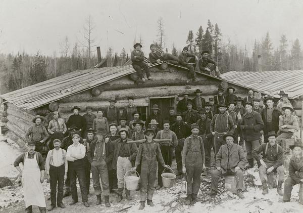 Lumber crew posed in front of a building at Ole Emerson's lumber camp.