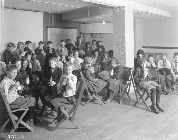 Classroom full of school children drinking milk at Washington school.