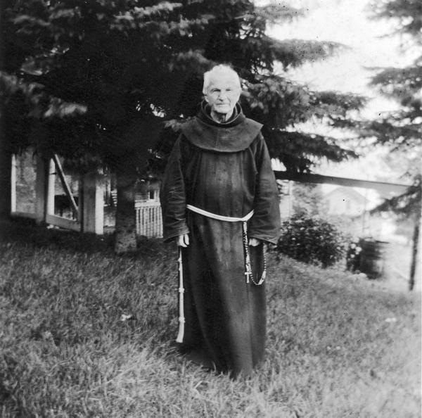 Reverend Chrysostom Verwyst in an outdoor candid pose, wearing his robe.