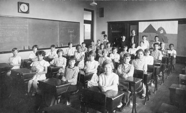 View of the Longfellow School's 4th grade class seated at their desks as their teacher stands at the back of the classroom.