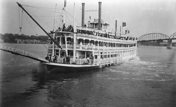 A bow view of the sternwheel excursion, <i>J.S.</i>, near Lyons, Iowa (now called Clinton) with an excursion party aboard taken between 1901 and 1910. Bridge in background.