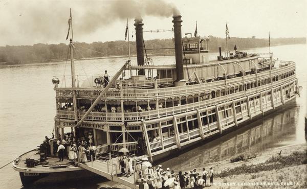 The sternwheel excursion, <i>Sidney</i>, later named <i>Washington</i>, landing at Bellevue. Passengers are disembarking. A sign on the ship reads Streckfus Lines.