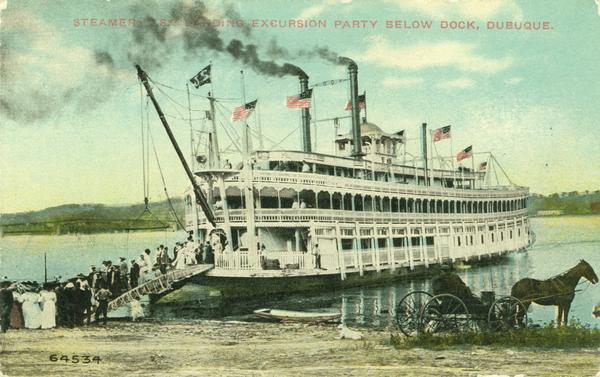 The sternwheel excursion <i>J.S.</i>, loading an excursion party below dock. Horse and cart in foreground. Caption reads: "Steamer J.S. Loading Excursion Party Below Dock, Dubuque."