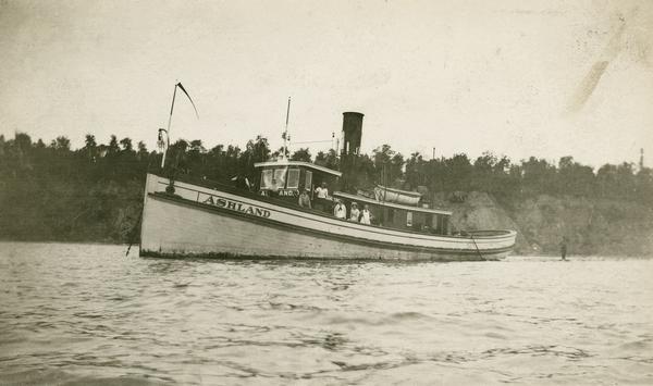 The tugboat Ashland with several passengers visible on deck.