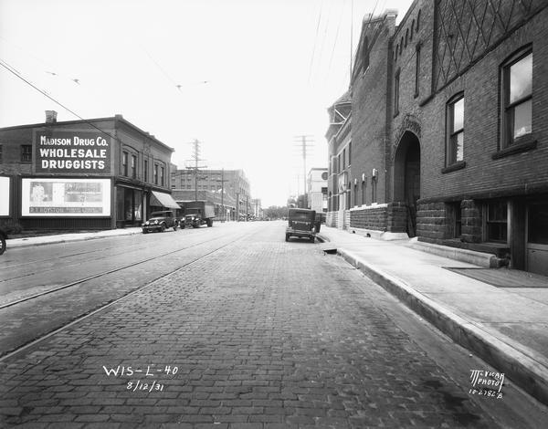 Fauerbach Brewery on the right, at 651-653 Williamson Street. Looking northeast along Williamson Street is the Madison Drug Co., 654 Williamson Street, International Harvester Co., 706 Williamson Street, Mansfield-Caughey Co. Ice Cream, 701-705 Williamson Street, and General Paper and Supply, 714-716 Williamson Street.