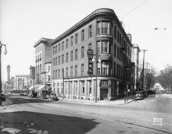 Commercial National Bank The Commercial National Bank building, on the corner of State and Carroll Streets, housed the bank as well as Mrs. Brown's Beauty Shoppe and Wegener and Roick Lawyers. On the right is a view down Carroll Street towards Lake Mendota. On the left down State Street among many other storefronts is the Palace Drug Store, the YWCA, and the marquee for the Orpheum Theatre.
