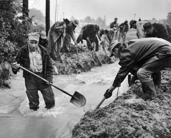 Men with shovels during the flood at Villa Louis.