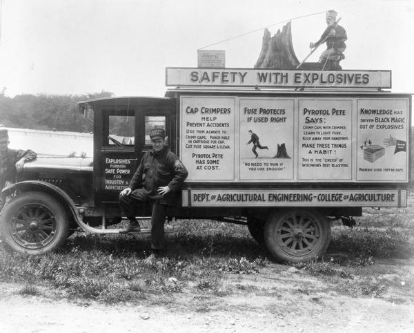 A Wisconsin Department of Agriculture truck with a sign that reads "Safety With Explosives." The truck and workers were part of a crew that blew tree stumps out of cutover land.