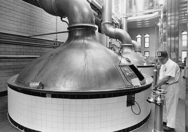 Richard A. Schulz is checking a kettle of beer brewing at the Pabst Brewery.