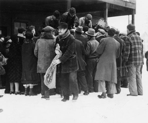 People receiving fish at a relief station in the wintertime.