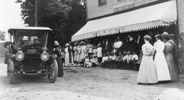 Suffragist Mrs. Katherine McCullough speaking to a gathering in front of the store and post office run by Mrs. W. Bunda in Sister Bay.