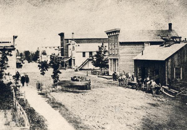 Elevated view of Barstow Street looking north. View from the corner of Main Street, where the Eau Claire Book and Stationary Company later stood, looking north. The white building with outside stairway is at the location later occupied by the Culver shoe store.