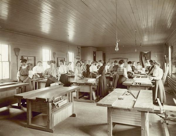 Women working with tools, including a saw, in the University of Wisconsin Agricultural Extension women's carpentry class.