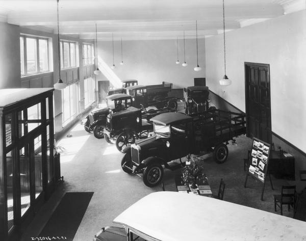 Elevated view of the showroom of an International motor truck dealership or branch in Canada(?) with several trucks, a few desks, and potted plants.