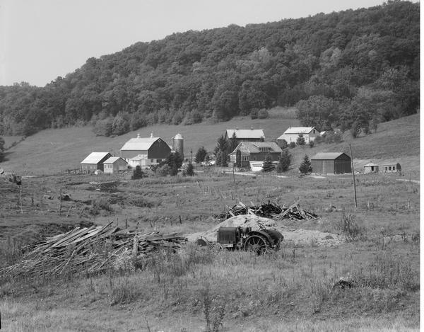 Farm buildings in the Coulee country, with old tractor in foreground.