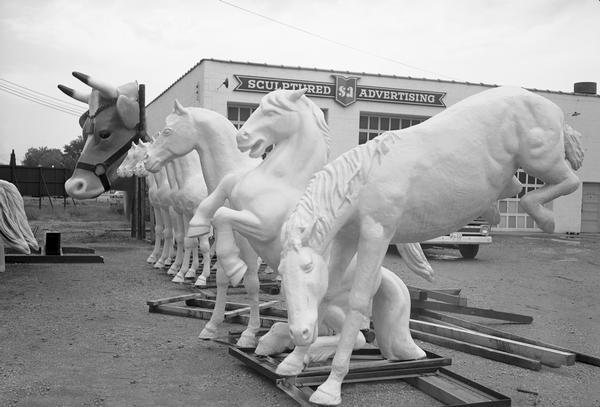 A row of sculptured horses and a cow's head at the Creative Display Company, currently known as the FAST Corporation.
