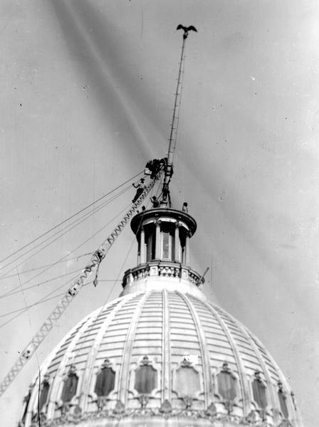 The dismantling of the dome of the third Wisconsin State Capitol began with the removal of the 32-foot flagpole. The eagle at the top of the pole was an 1889 replacement for the original eagle. The dome was taken apart and the pieces stored behind Bascom Hall for reconstruction on that University of Wisconsin building. When that idea was rejected the dome was sold for scrap. Lew Porter, superintendent of construction for the fourth Capitol, rescued the 1889 eagle for the Bascom Hall proposal. It is now on public display in the Historical Society's Headquarters building.