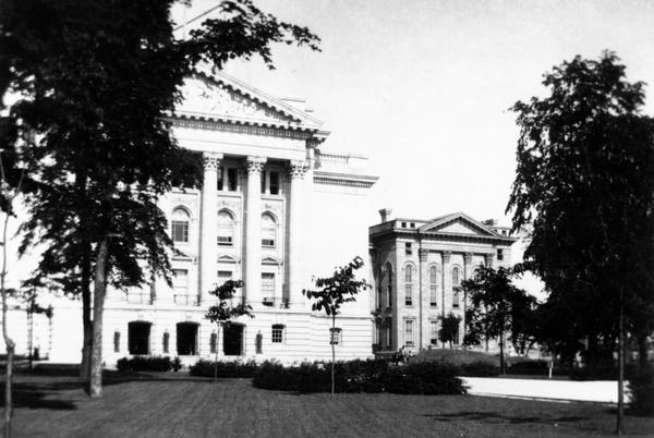 The fourth Wisconsin State Capitol on the left, with the North Wing of the old Capitol still standing at right.  The North Wing was not damaged by the fire of 1904 and it continued to be used until 1913.