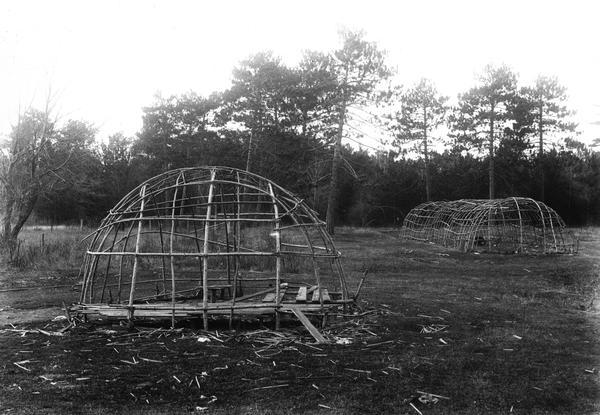 Framework for a Chippewa (Ojibwa) wigwam (left) and long medicine lodge at Lac du Flambeau. This image is part of an exhibit about Native Americans prepared by Paul Vanderbilt, the Wisconsin Historical Society's first curator of photography.
