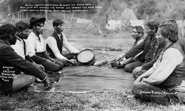 Postcard depicting a group of Potawatomi men at Stone Lake playing the game of moccasin.  This image is part of an exhibit about Native Americans prepared by Paul Vanderbilt, the Wisconsin Historical Society's first curator of photography.