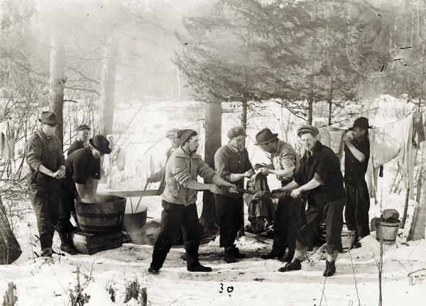 The men of Rice Lake Lumbering Camp #6 do their laundry on a Sunday.
