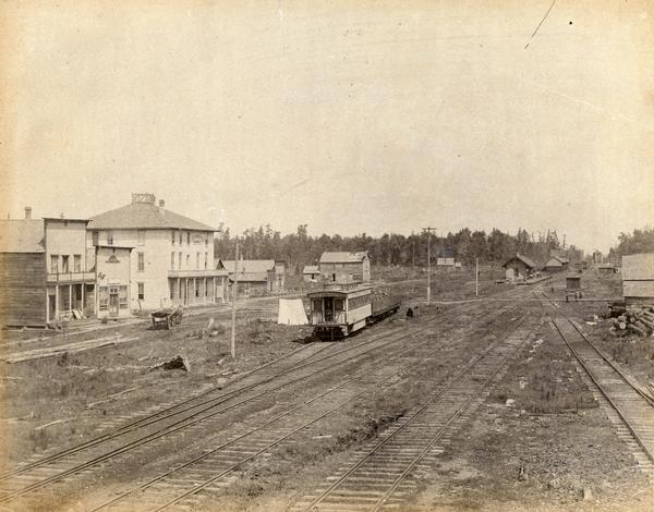 View of Chelsea including railroad tracks and car.