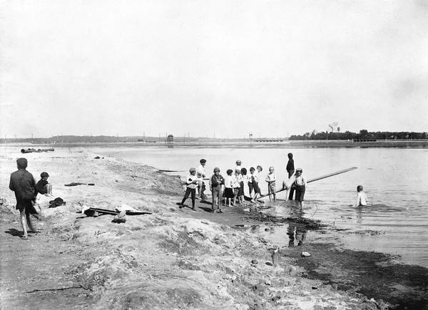 Group of children playing with a makeshift diving board at Brittingham Bay swimming hole.