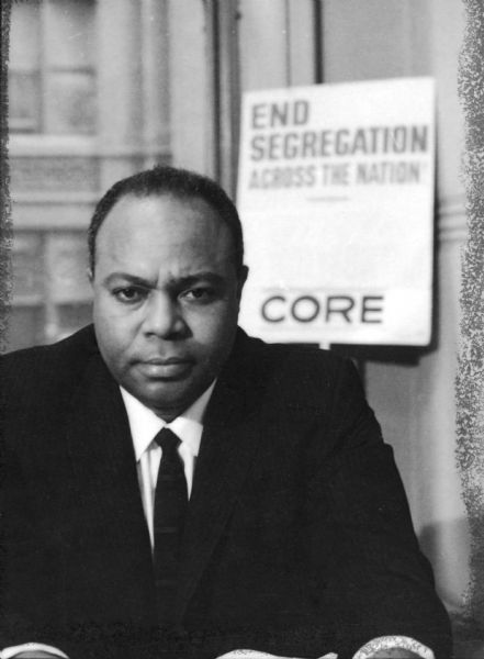 Portrait of James L. Farmer, Jr. sitting at his desk with a "End Segregation - CORE" poster behind him. James Leonard Farmer, Jr. was a civil rights activist and leader of the American Civil Rights Movement. He co-founded the Committee of Racial Equality in 1942, which later became the Congress of Racial Equality (CORE). He was also the initiator and organizer of the 1961 Freedom Ride, which eventually led to the desegregation of inter-state transportation in the United States.